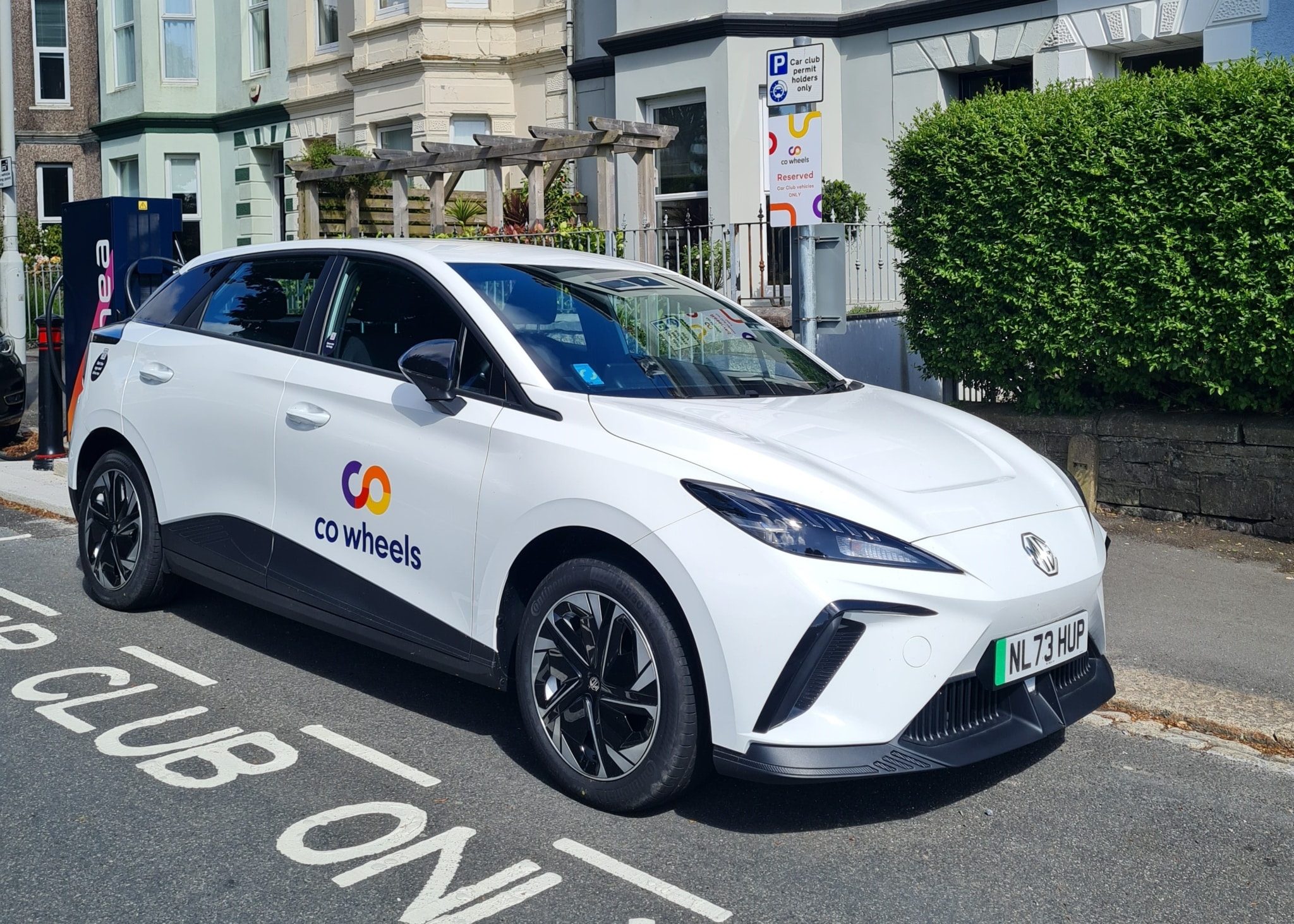 A Co Wheels electric vehicle is parked in a car club bay on a Plymouth road.