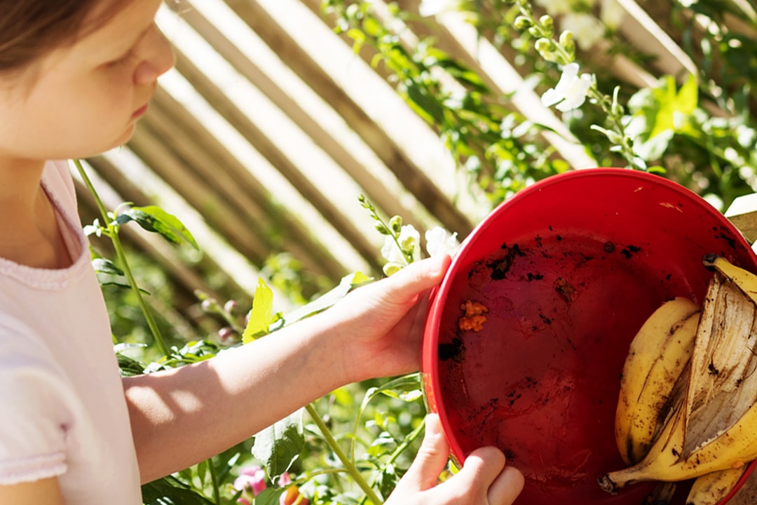 Young girl composting food waste for community composting