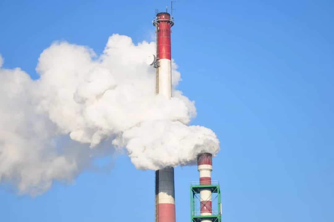 Smoke stacks against a bright blue sky